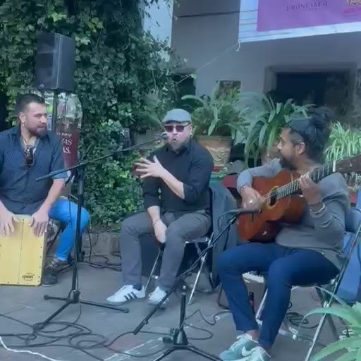 Musicians performing together with guitar and cajón at an RMR Mundial event.